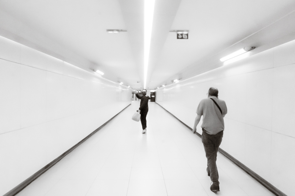 Un homme marchant dans le couloir de la station de métro La Joliette se retourne au moment où je shoote et fait le signe de la victoire.