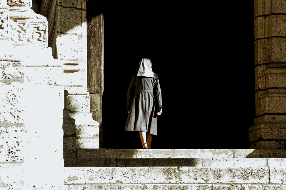 Une bonne sœur photographiée de dos, pénètre dans la cathédrale de Chartres.
