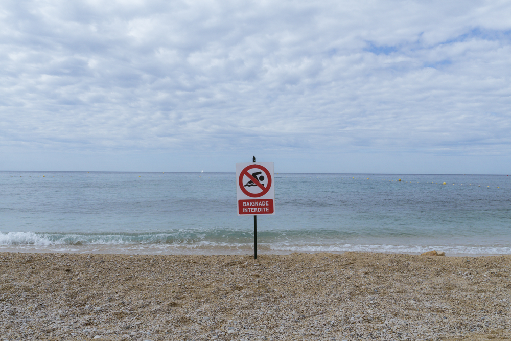 Un panneau Baignade Interdite planté en plein milieu de la plage de la Grande Mer à Cassis.