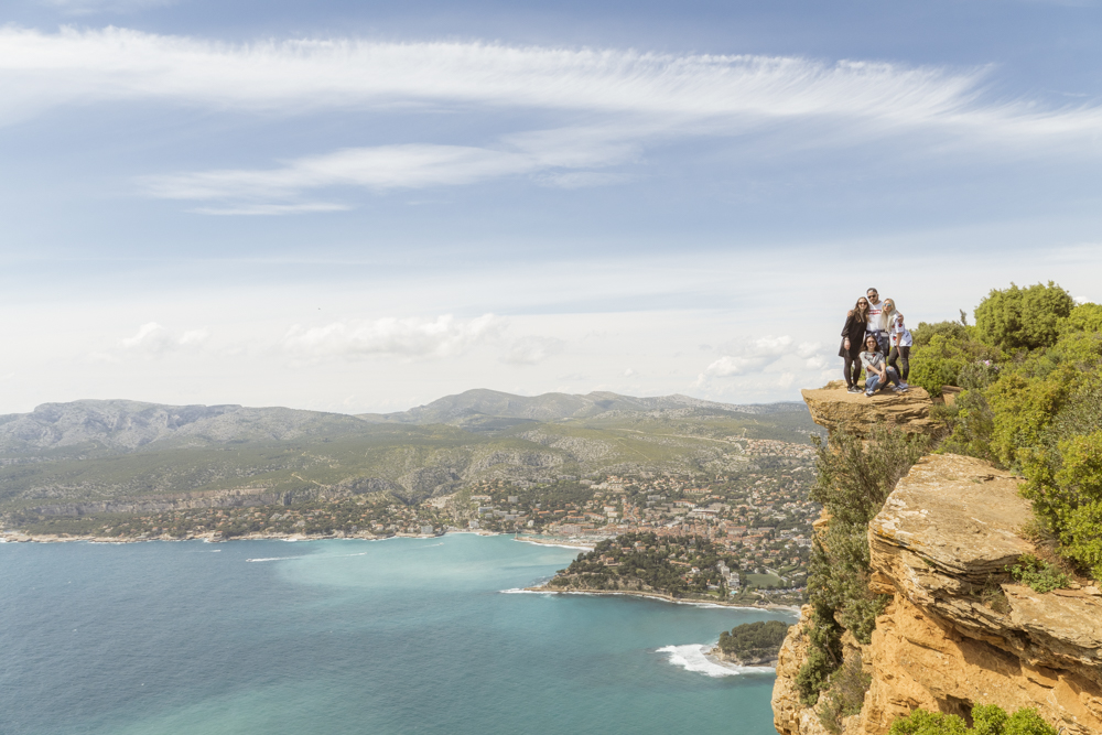 Une groupe de 4 touristes posant pour la photo tout au bord d'une falaise de 399 mètres de haut.
