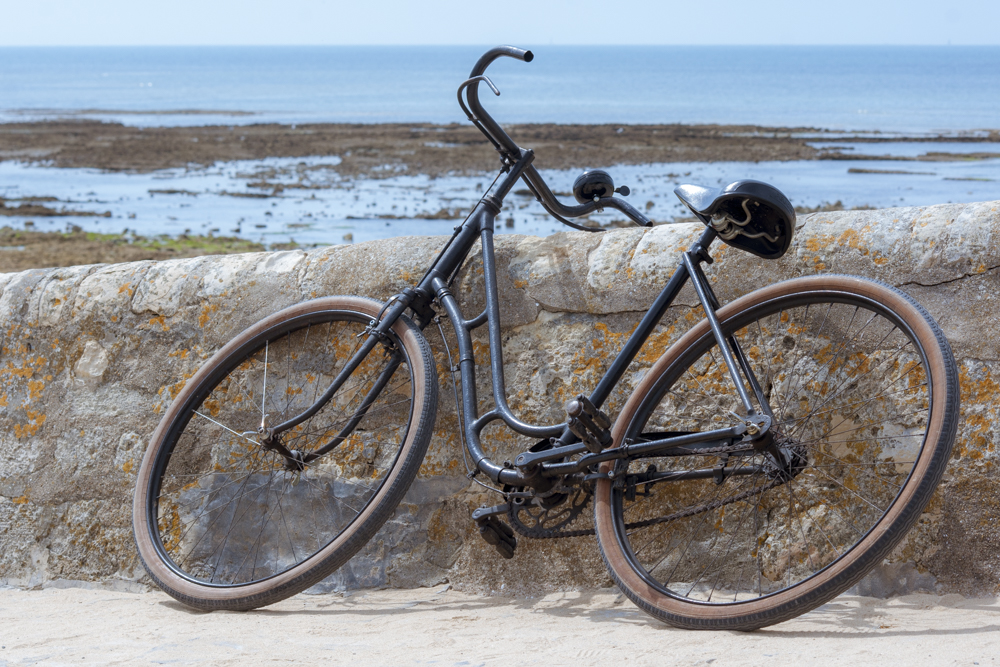 Un vélo vintage posé contre le mur d'une rampe donnant accès à la plage d'Ars-en-Ré
