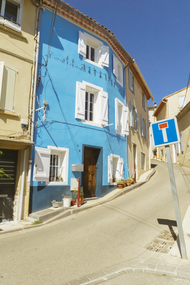 Une maison à la façade toute bleue dans une rue du village d'Allauch.