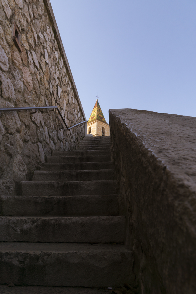 Le clocher de l'église Saint Sébastien à Allauch dans le prolongement de l'escalier du cours du 11 novembre.