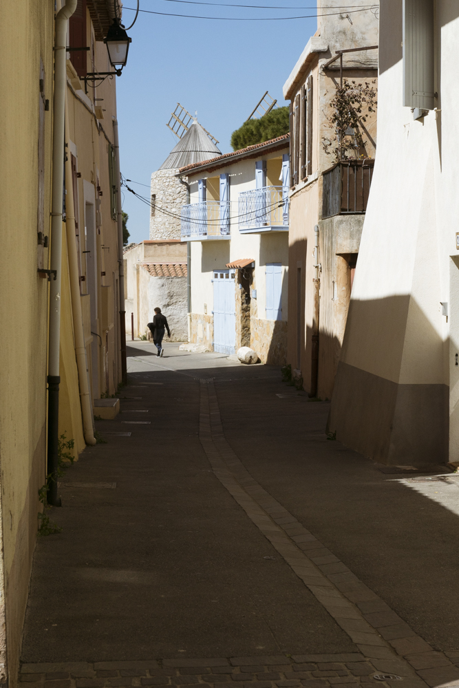 La silhouette d'une personne marchant dans la rue en direction d'un moulin à vent.