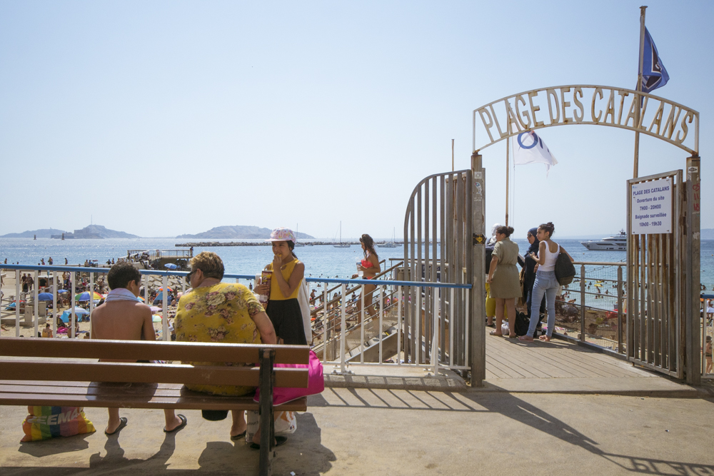 Une dame avec ses enfants ou petits-enfants à la sortie de la plage des Catalans à Marseille après une journée de baignade.