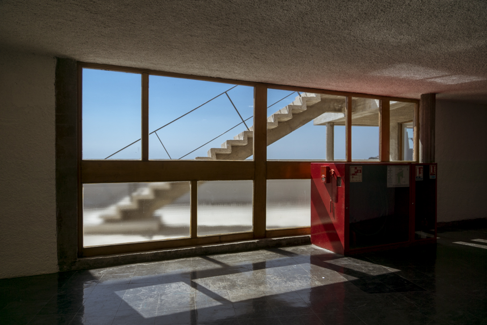 Au dernier étage de la Cité Radieuse du Corbusier à Marseille, une baie vitrée nous offre une vue sur le toit-terrasses en laissant passer la lumière.
