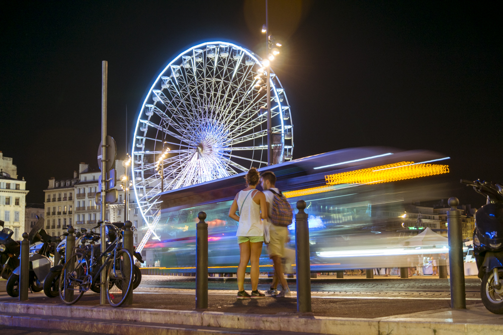Un couple arreté sur le trottoir semble chercher son chemin dans la nuit marseillaise.